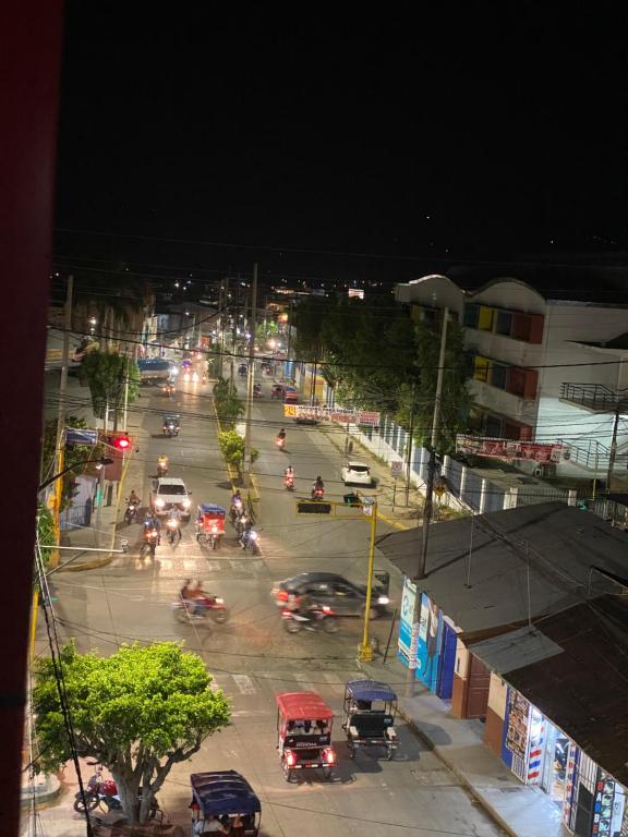 uma movimentada rua da cidade com carros e trânsito à noite em HOSPEDAJE PISCIS TARAPOTO em Tarapoto