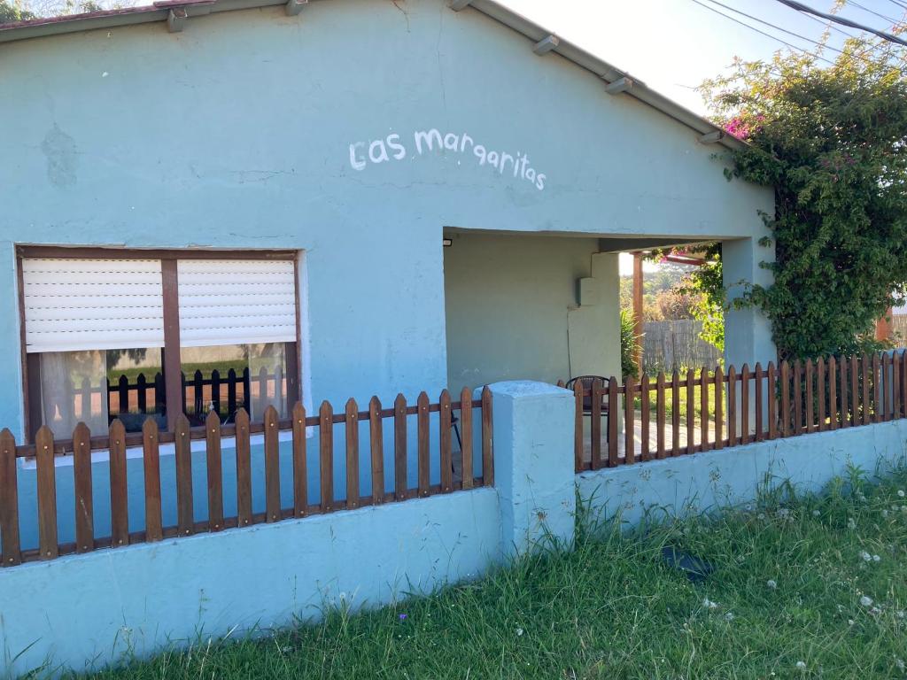 uma casa azul com uma cerca em frente em Las Margaritas em La Coronilla