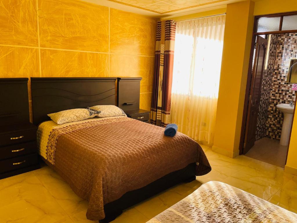 um quarto com 2 camas e uma parede amarela em DIAMEZ HOTEL PLAZA em Sacaba