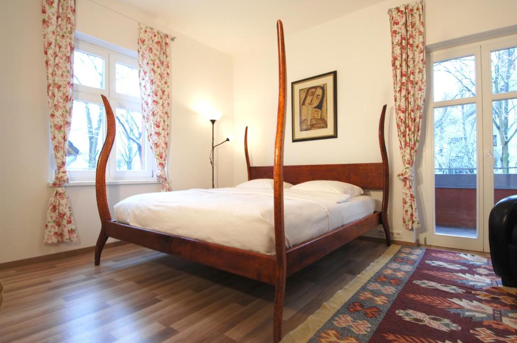 ein Schlafzimmer mit einem Himmelbett in einem Zimmer mit Fenstern in der Unterkunft Apartement in Stadtvilla in Berlin