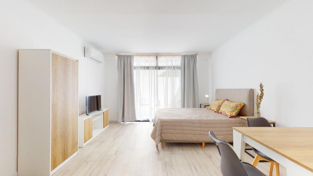 1 dormitorio con cama, mesa y TV en Parque57 alquiler temporario con patio La Plata en La Plata