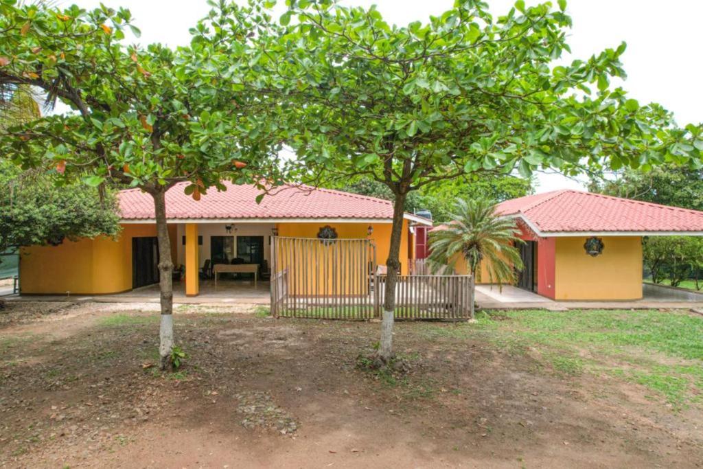 una casa con dos árboles delante de ella en Las QuiNtas Casas para VacacionaR en Coco