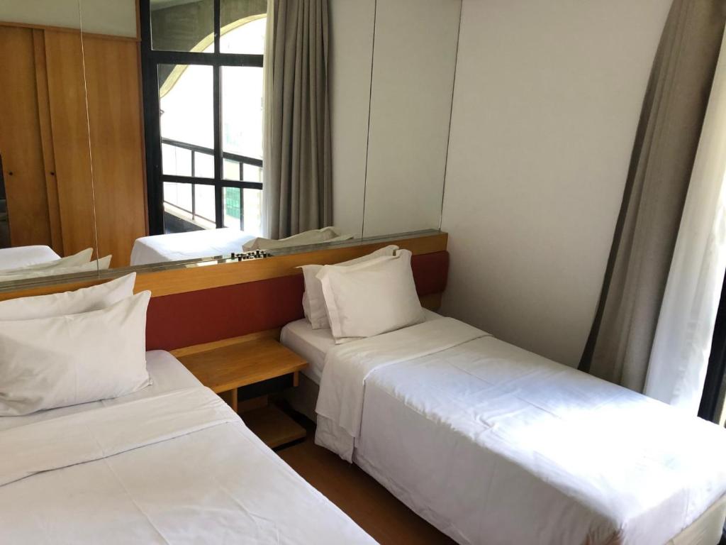 Habitación de hotel con 2 camas y ventana en FLAT-HOTEL Faria Lima Itaim São Paulo, garagem inclusa !, en São Paulo