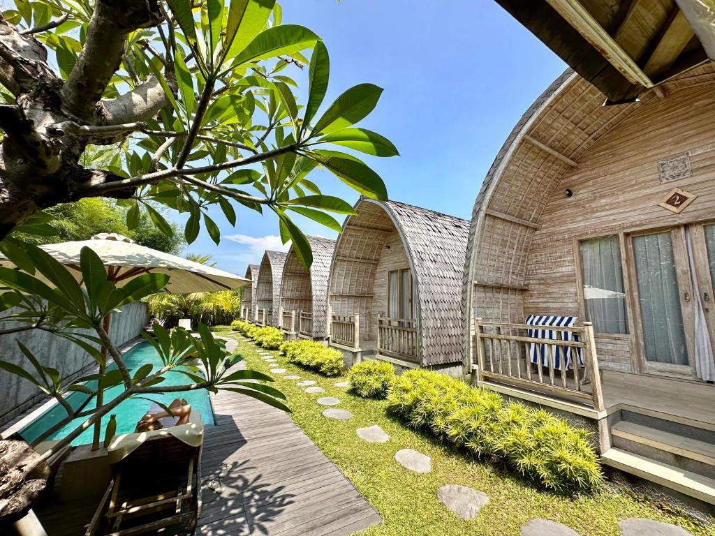 a house with a swimming pool next to a building at Tanhana Villa Canggu in Canggu