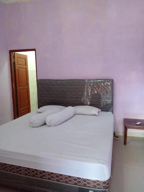 uma cama com duas almofadas num quarto em BRAVILIA GUEST HOUSE em Sorong