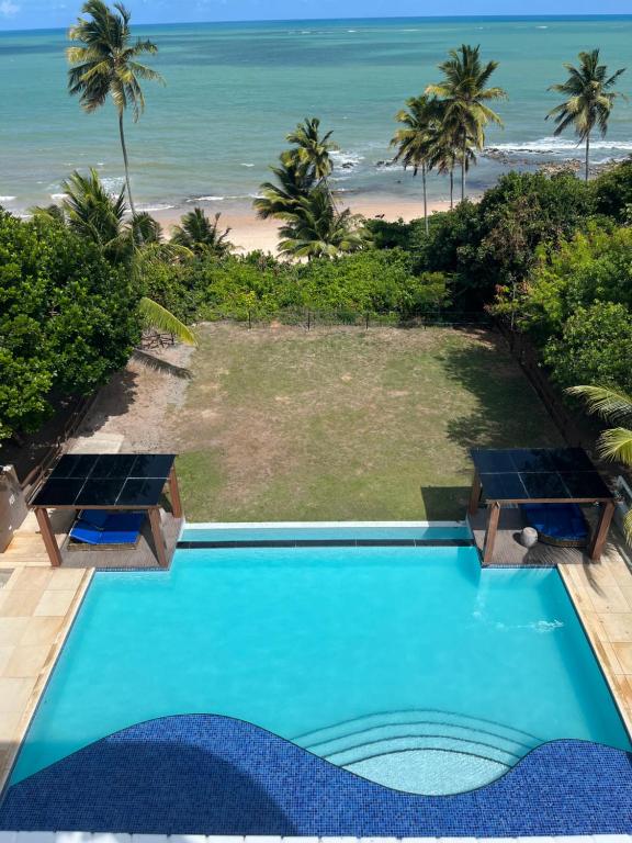 a swimming pool with a view of the beach at Flat Beira Mar Carapibus in Conde