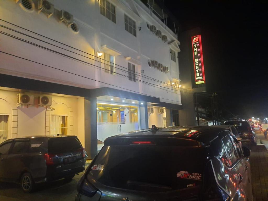 dos autos estacionados frente a un edificio por la noche en The Bonte Hotel, en Puunggolaka