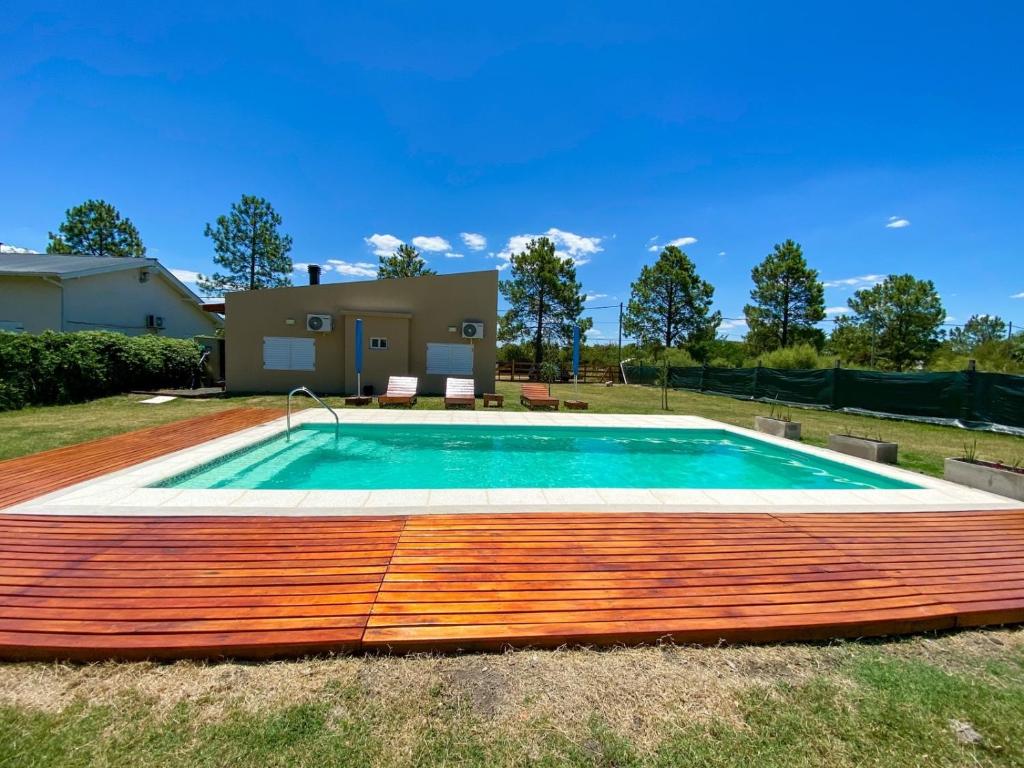 a swimming pool with a wooden deck around it at Pinares del Norte in Federación
