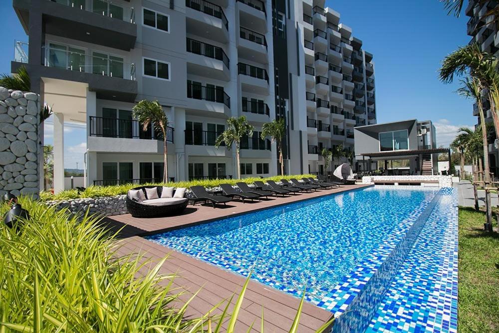 a swimming pool in front of a building at Mantra Beach condominium M116,M140 in Ban Phlong Sawai