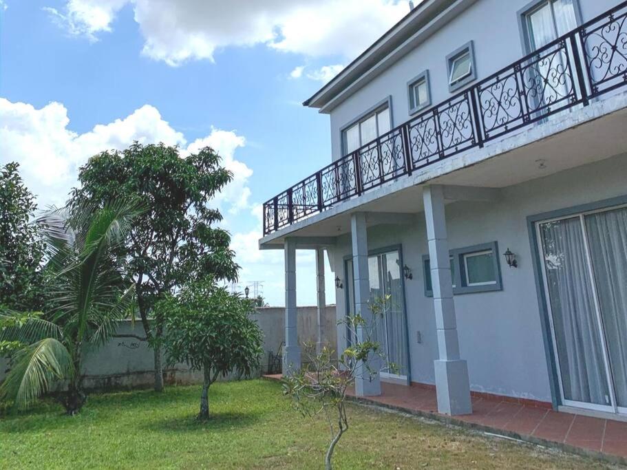 een wit huis met een balkon aan de zijkant bij Santai Homestay Jb in Johor Bahru
