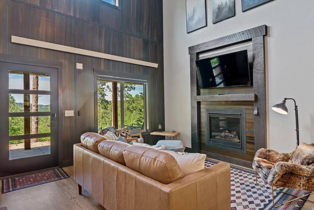 a living room with a couch and a fireplace at High Mountain Rustic Cabin Hot Tub Game Loft in Lead