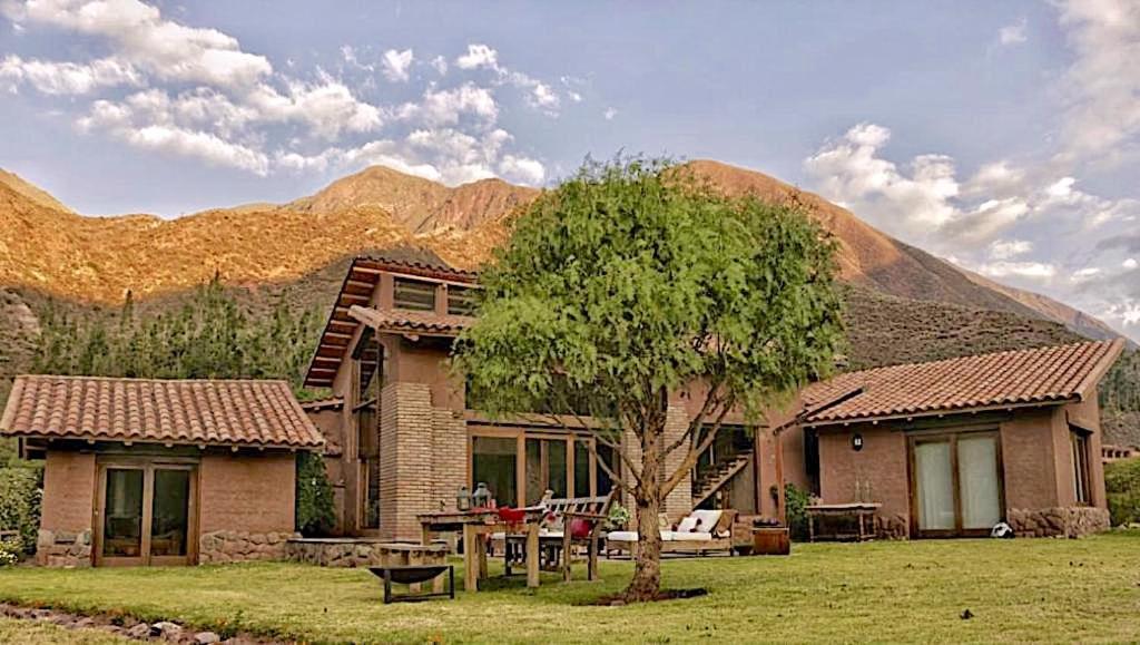 una casa con un árbol frente a una montaña en Luxury House at Sacred Valley Urubamba Cusco The Mountain Star, en Urubamba