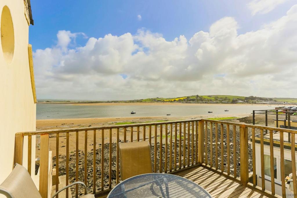 a balcony with a table and a view of the beach at APPLEDORE GANNETS NEST 3 Bedrooms in Appledore