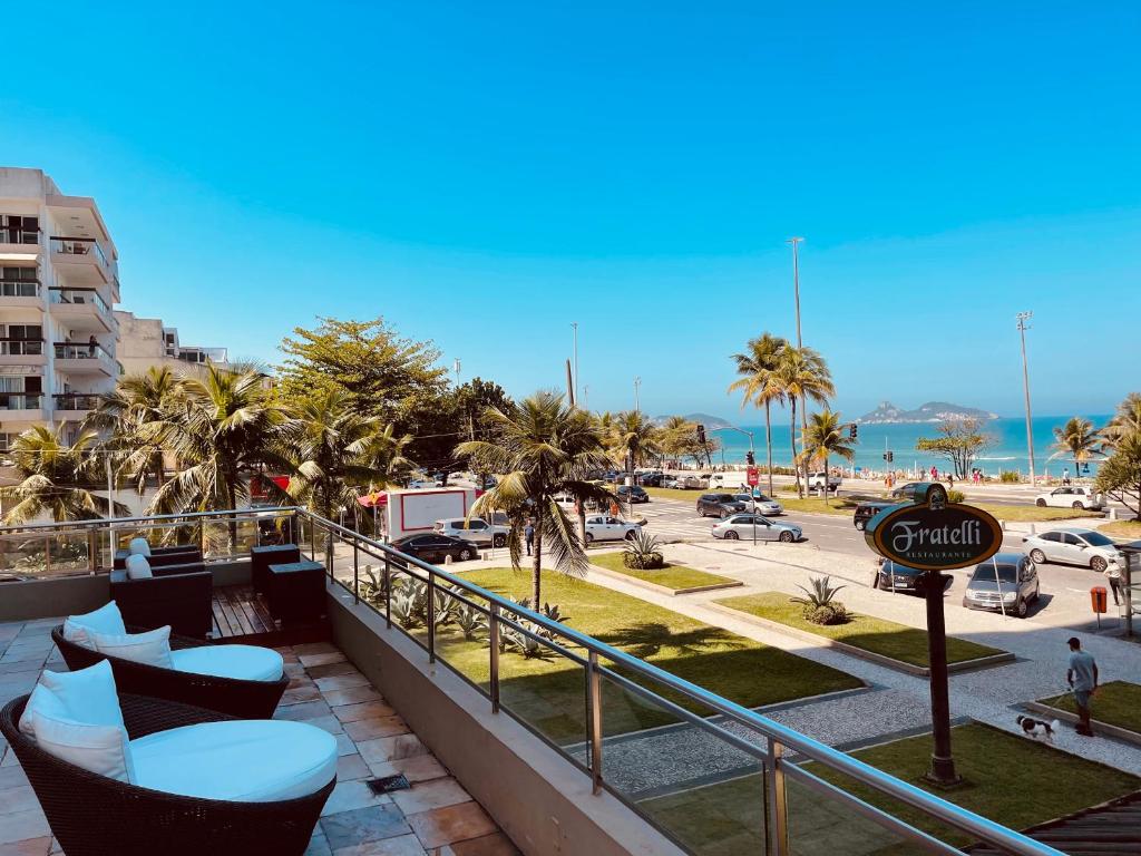 a balcony of a resort with chairs and a parking lot at Pé na areia! Apart hotel com vista para o mar e lazer completo! Front beach apartment with ocean view and amenities! in Rio de Janeiro