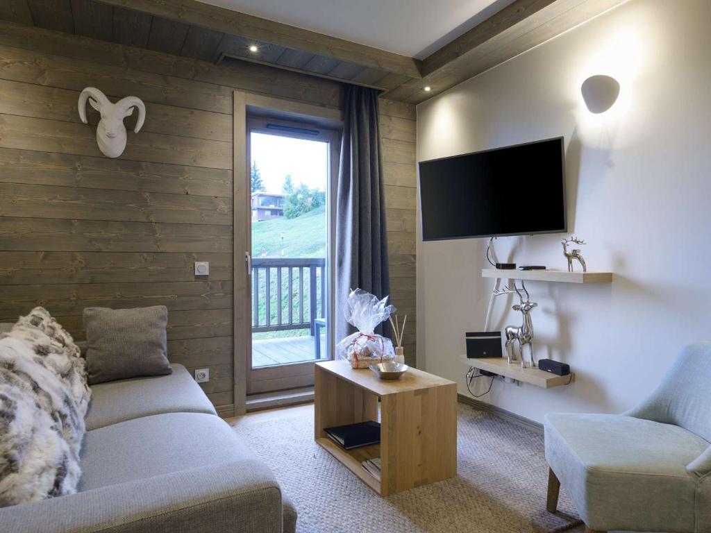 un salon avec un canapé et une télévision à écran plat dans l'établissement Courchevel Moriond: Appartement 42m², 4 pers, proche pistes avec WIFI et parking - FR-1-631-115, à Courchevel