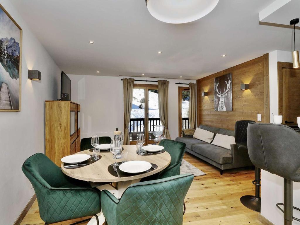 une salle à manger et un salon avec une table et des chaises dans l'établissement Appartement rénové 42m² - 4 pers - Courchevel 1550, Sud, skis aux pieds, proche centre, parking inclus - FR-1-631-121, à Courchevel