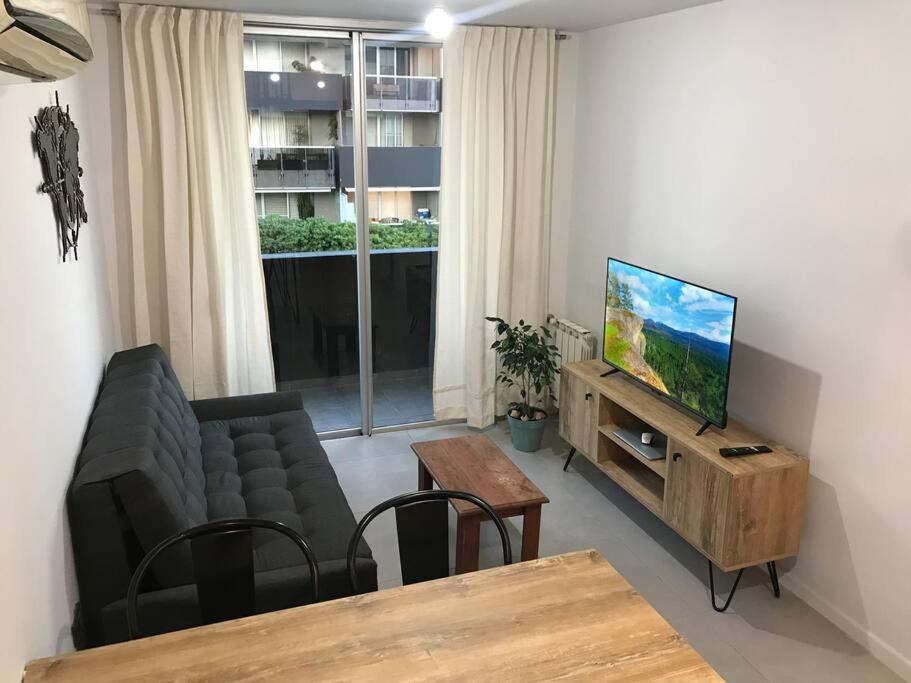 sala de estar con sofá y TV de pantalla plana en Moderno departamento en complejo premium en Córdoba