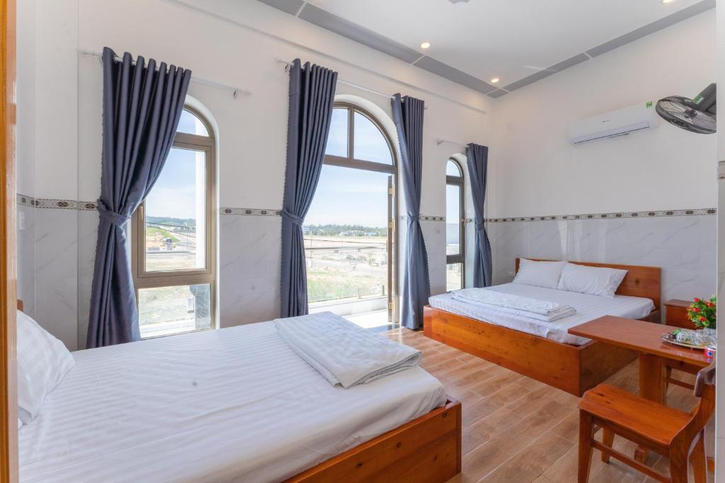2 camas en una habitación con ventana en Homestay Bảo Châu - Nhơn Lý Quy Nhơn, en Quy Nhon