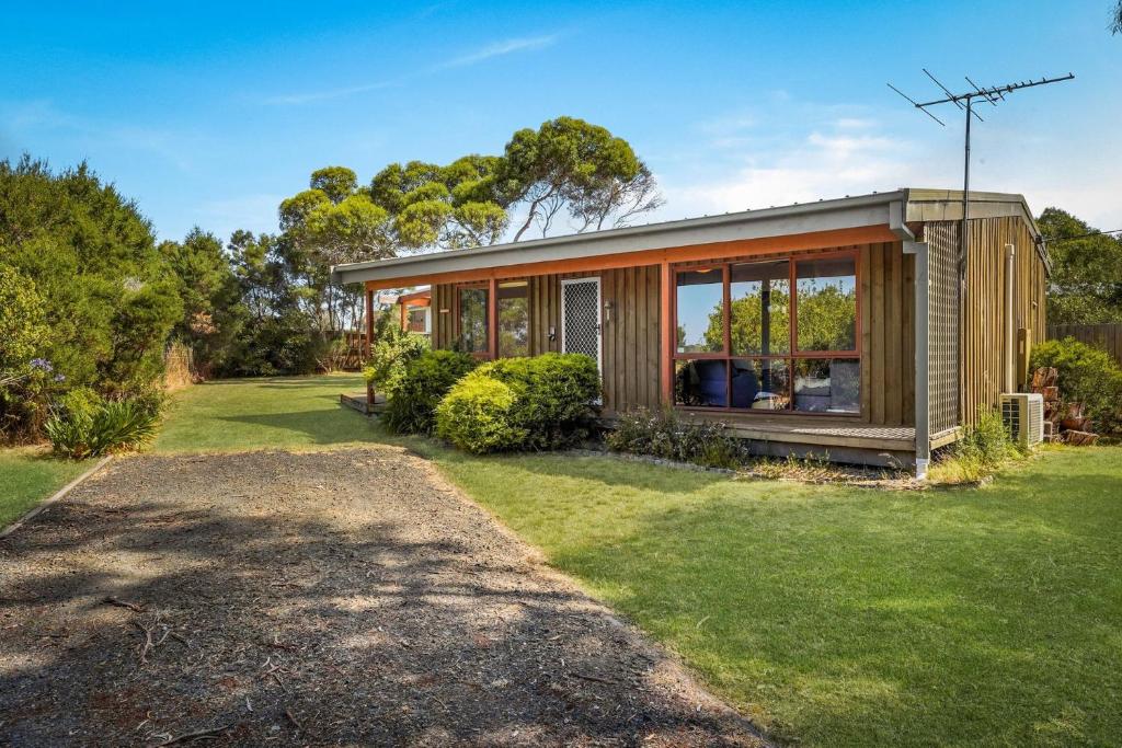a small house with glass doors on a yard at Philippas Paddock in Cowes