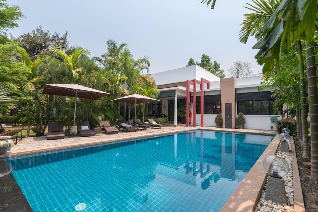 a swimming pool in front of a house at Countryside Villa, 2 Bedroom Villa, Infinity Pool and maid service in Chiang Mai