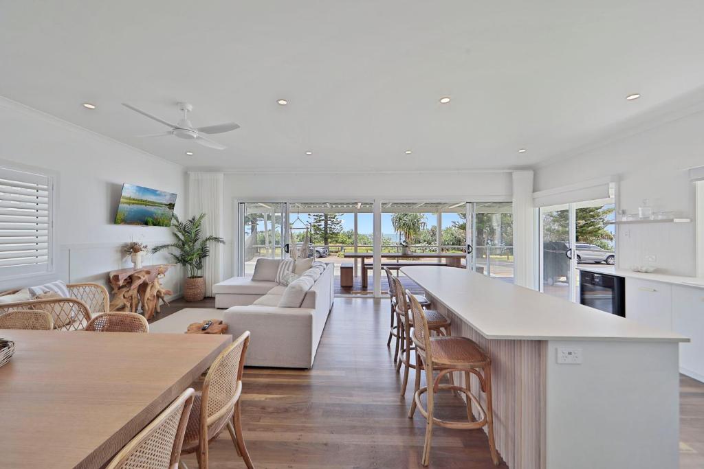 uma cozinha e sala de estar com mesa e cadeiras em The Lookout em Bargara