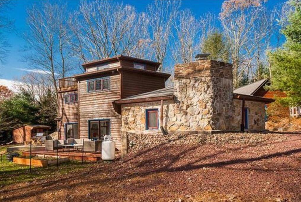 a large stone house with a stone chimney at Spacious Pocono Getaway - Castle Blackberry in Jim Thorpe