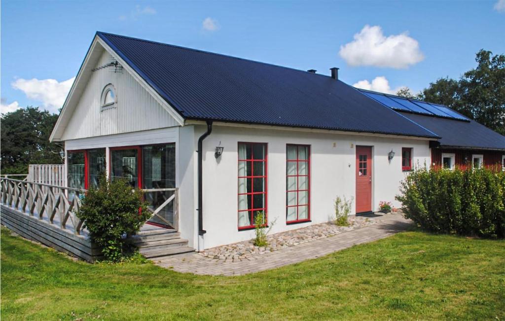 a white building with a black roof and red doors at Pet Friendly Home In Laholm With Wifi in Laholm