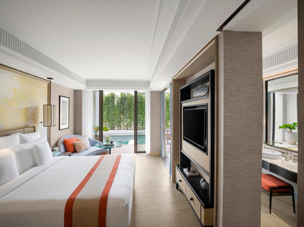 a hotel room with a bed and a television at InterContinental Phuket Resort by IHG in Kamala Beach
