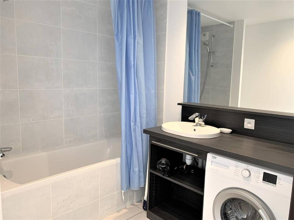 a bathroom with a sink and a washing machine at Appartement Quiberon, 2 pièces, 2 personnes - FR-1-478-162 in Quiberon