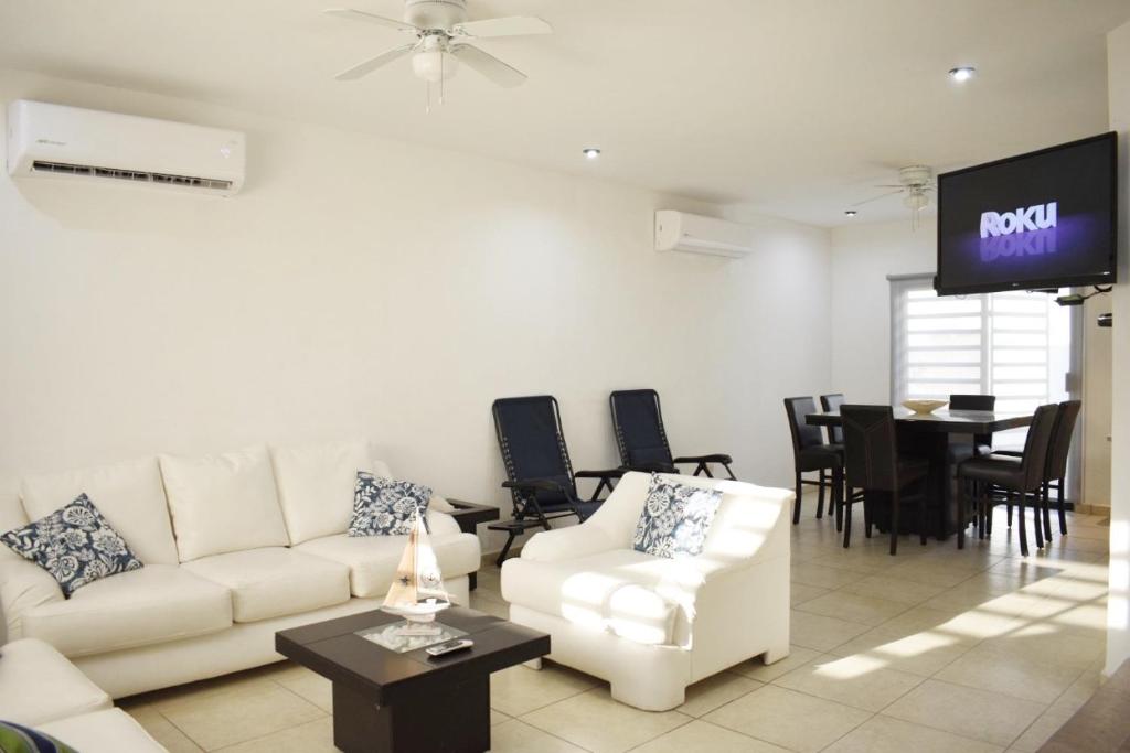 a living room with a white couch and a tv at 3 HABITACIONES, CERCA DE LA PLAYA, Cantera Residencial in San Carlos