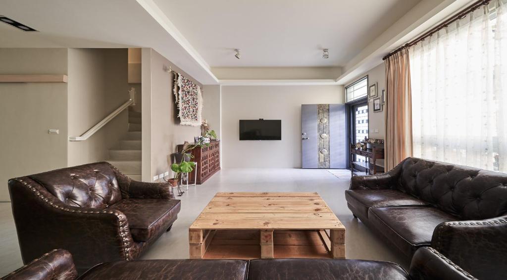 a living room with leather couches and a coffee table at 像個家plus民宿 AT home plus B&B in Hualien City