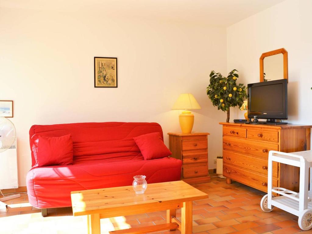 un salon avec un canapé rouge et une télévision dans l'établissement Studio lumineux avec terrasse et garage, 4 couchages, proche plage au Lavandou - FR-1-251-409, au Lavandou