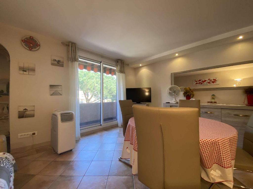 Cette chambre dispose d'une table, d'une télévision et d'une fenêtre. dans l'établissement Saint-Maxime Centre: Appartement T2 - 4 Couchages avec Parking et Plage à Pied - FR-1-226-483, à Sainte-Maxime