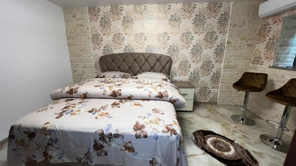a bedroom with a bed in a room with wallpaper at La Carmen 2 ! Apartament 1 camera! in Lupeni