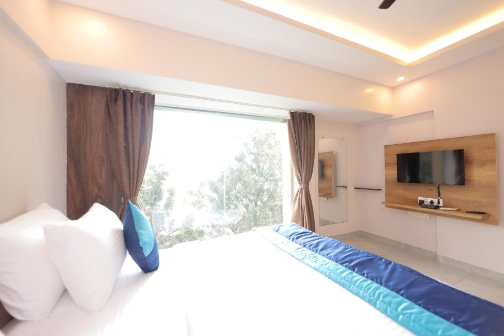 a bedroom with a bed and a large window at VOVO HOTELS in Yelahanka