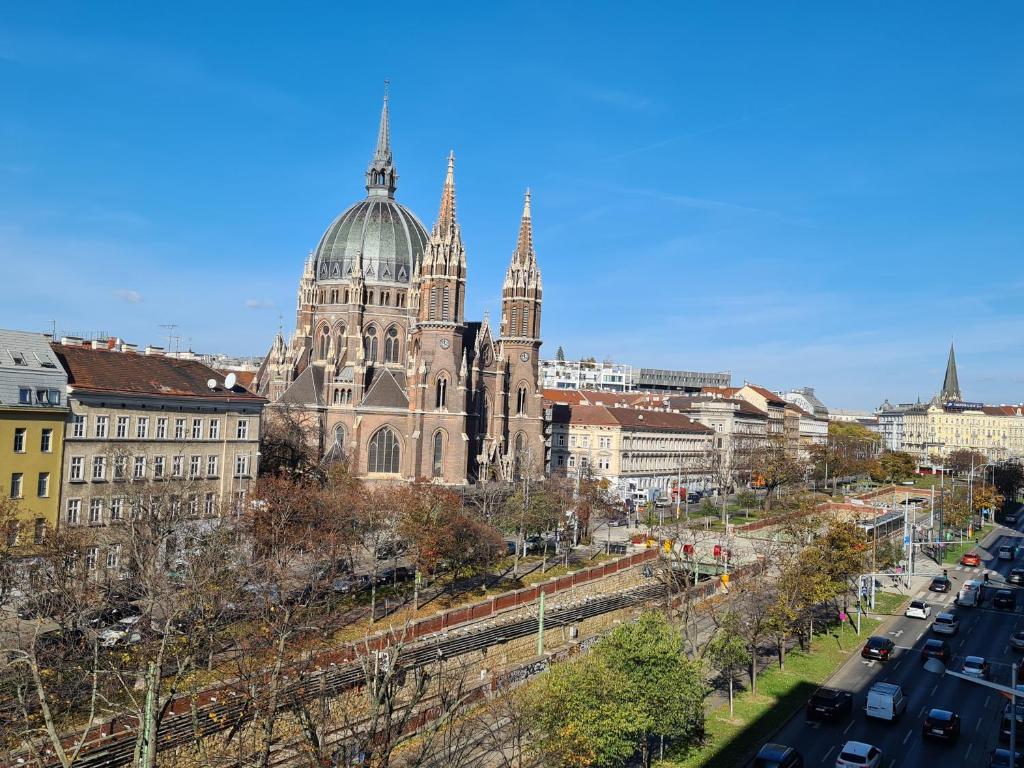 a large cathedral with two towers in a city at Open View City Apartment in Vienna