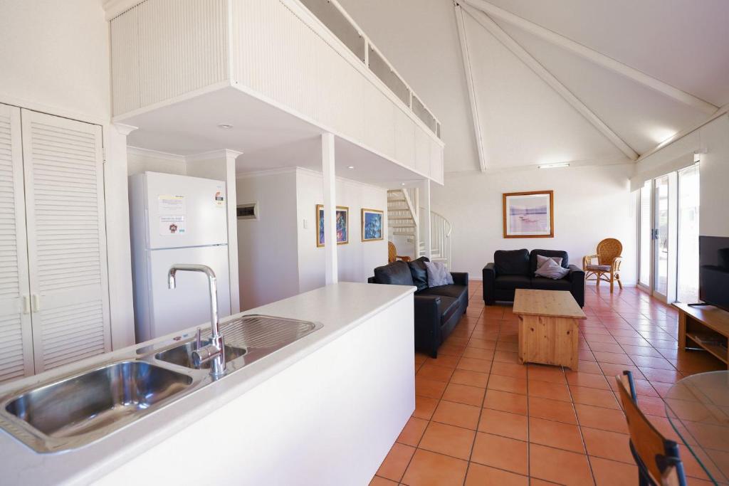 a kitchen with a sink and a living room at Osprey Holiday Village Unit 123 in Exmouth