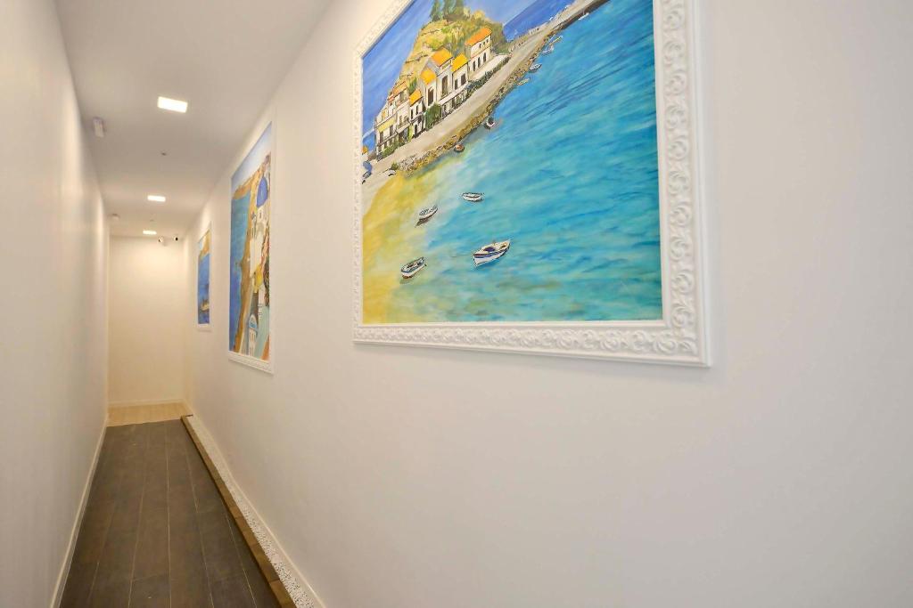 a hallway with paintings on a white wall at Otilia in Bucharest