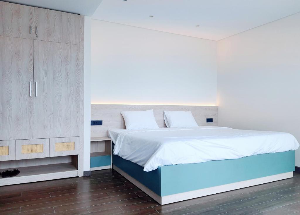 Beach Condotel - Apec Phú Yên في توي هوا: غرفة نوم بسرير كبير مع شراشف بيضاء