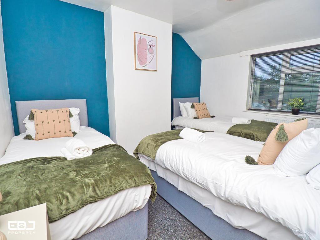 three beds in a room with blue and white walls at Supersized 5bed house/Birmingham/Monthly discounts in Birmingham