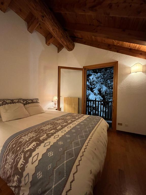 a bedroom with a bed in a room with a window at Chalet Blanc "La Mansarda" in Courmayeur