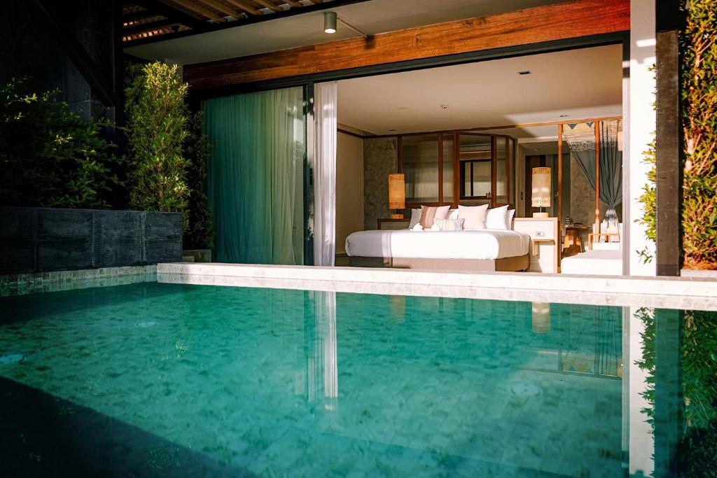 a pool in front of a bedroom with a bed at สิชลเตโซโร in Ban Thong Yang