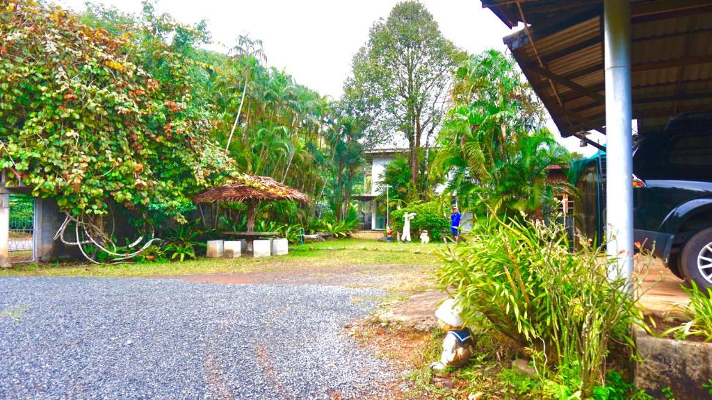 a road in front of a house with trees at Tanachporn Homestay ธนัชพร โฮมสเตย์ เมืองจันทบุรี in Chanthaburi