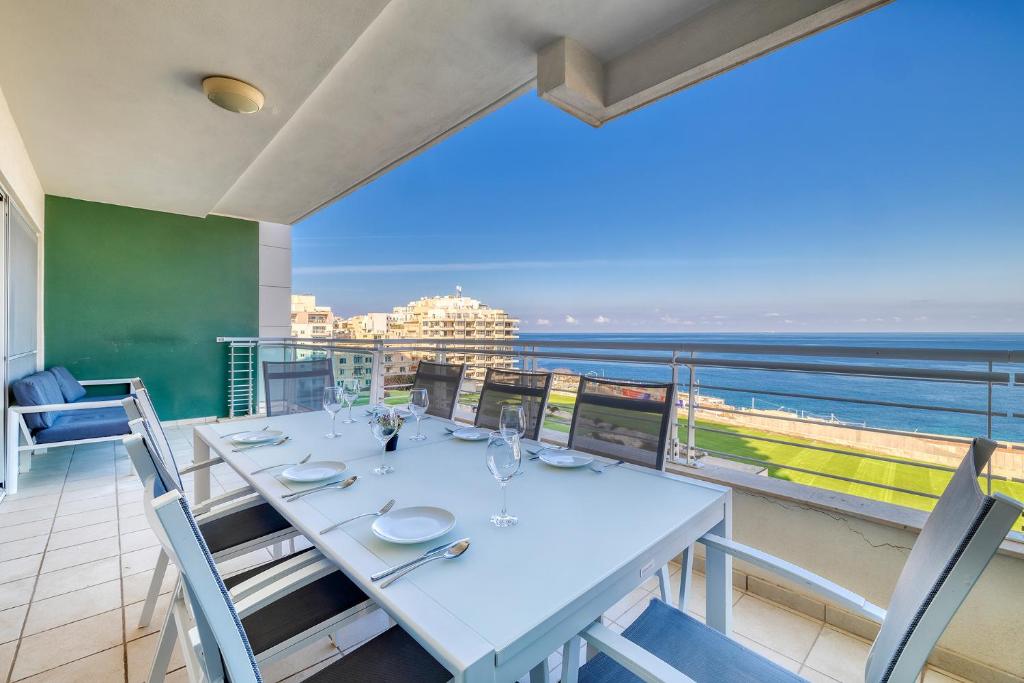 a dining room with a table and a view of the ocean at Stunning Seafront Lux Apt Fort Cambridge wt POOL in Sliema