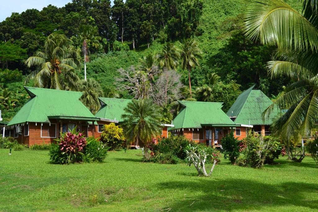 ein Haus mit grünen Dächern auf einem Grasfeld in der Unterkunft Daku Resort in Savusavu