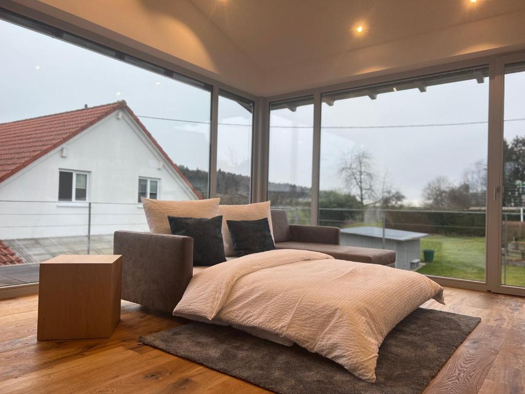 a bedroom with a bed and a large window at Landhaus zum See - Fewo Birke in Überlingen