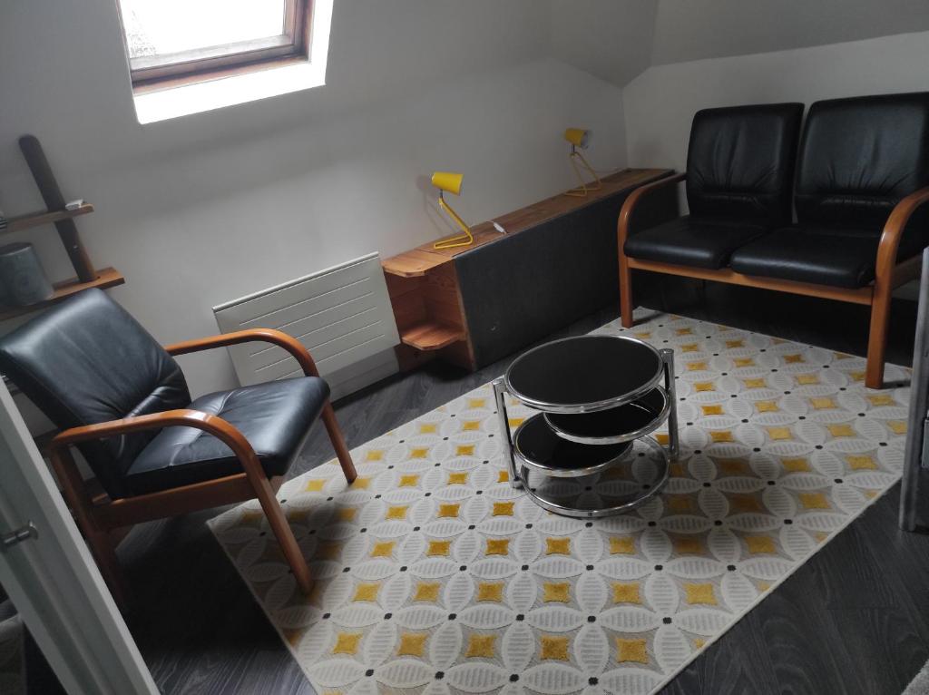 a living room with two chairs and a coffee table at Le studio d'Evelyne in Dieppe