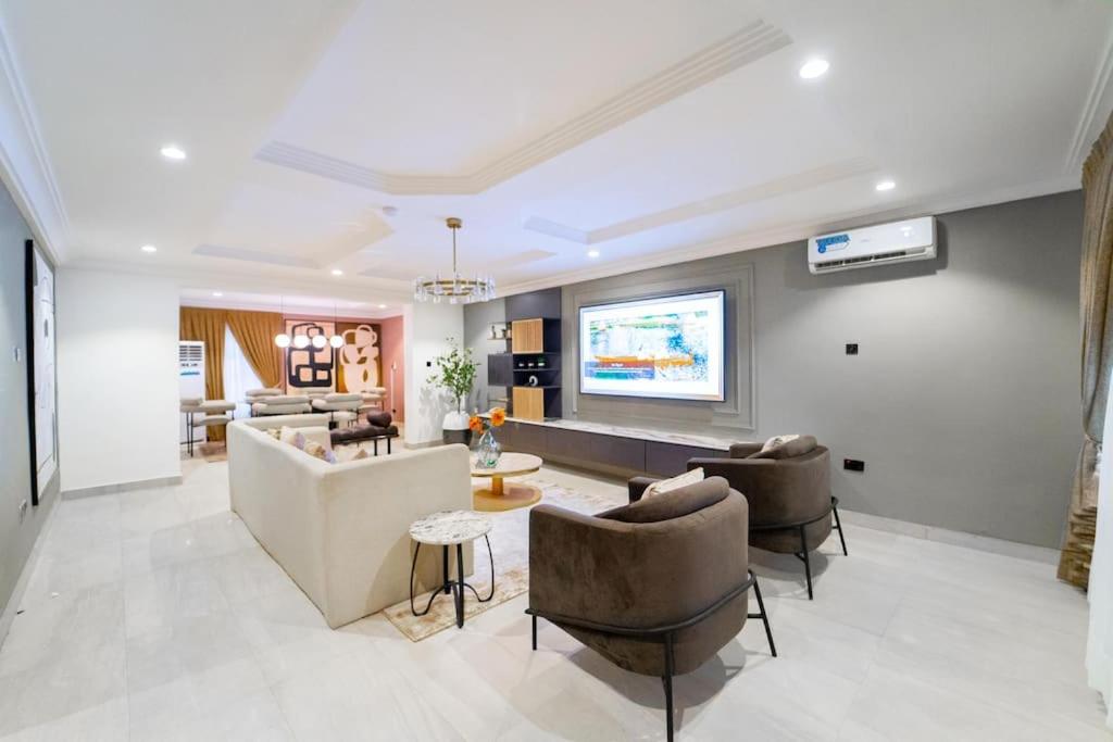 a living room with a couch and a tv at Luxury Condo in Ikoyi (banana Island) in Araromi