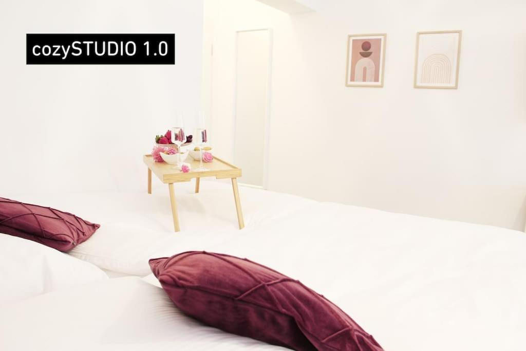 Zimmer mit 2 Kissen auf einem Bett mit einem Tisch in der Unterkunft SECRET HIDEAWAYS cozySTUDIO 1 superior Apartment mit WiFi l 450m bis Uni l Zoo in Duisburg