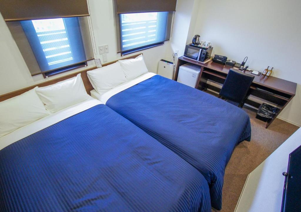 Postel nebo postele na pokoji v ubytování HOTEL LiVEMAX Kanazawa Ekimae